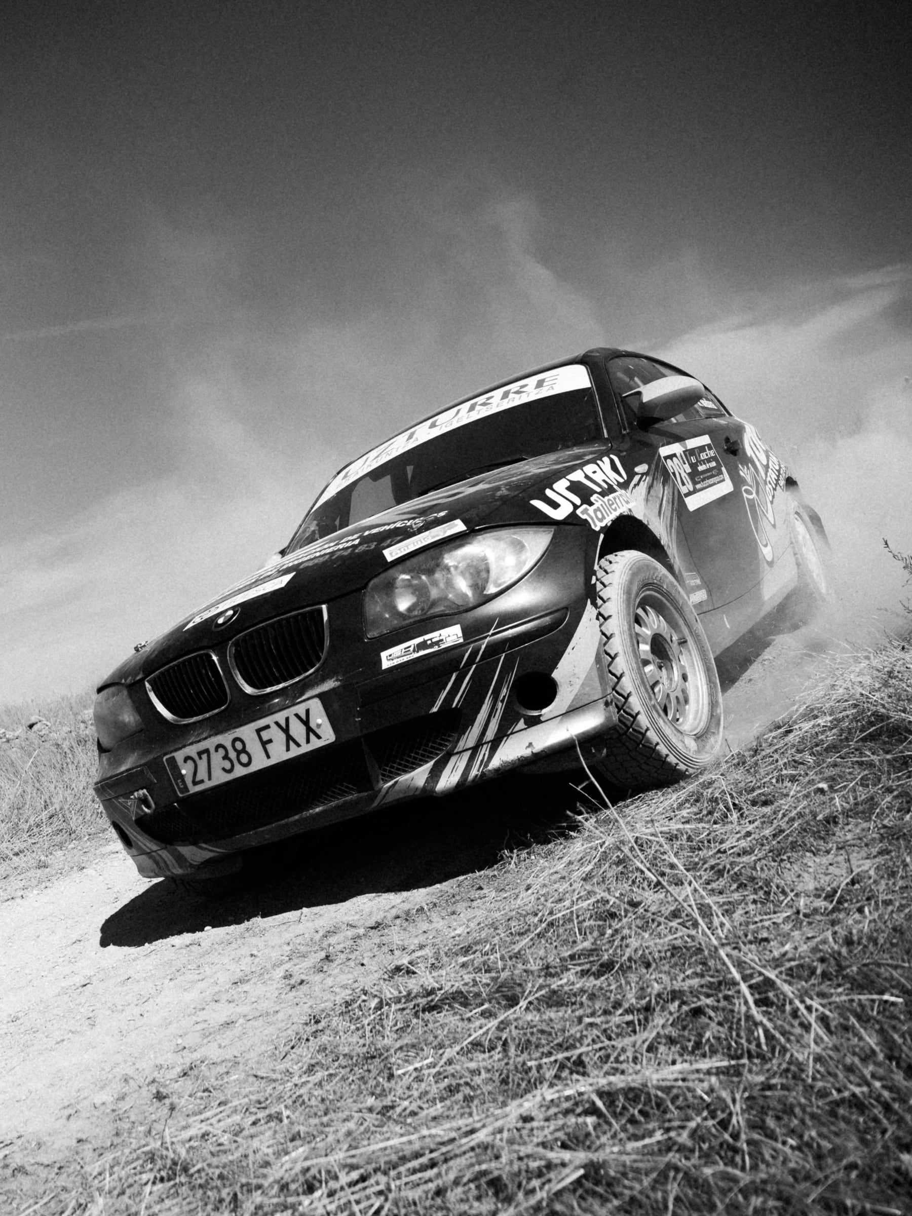 BMW Serie 1 en blanco y negro derrapando entre polvo