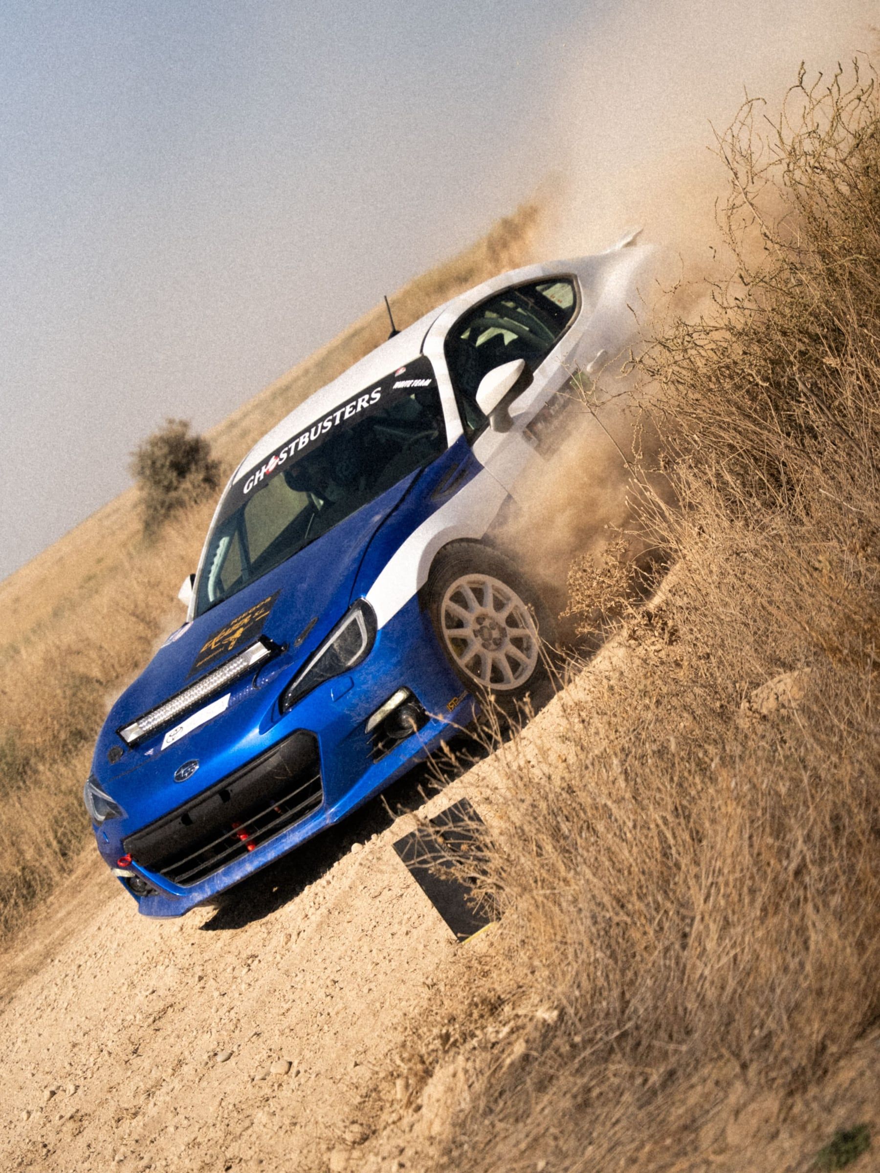 Toyota azul subiendo de lado por el talud