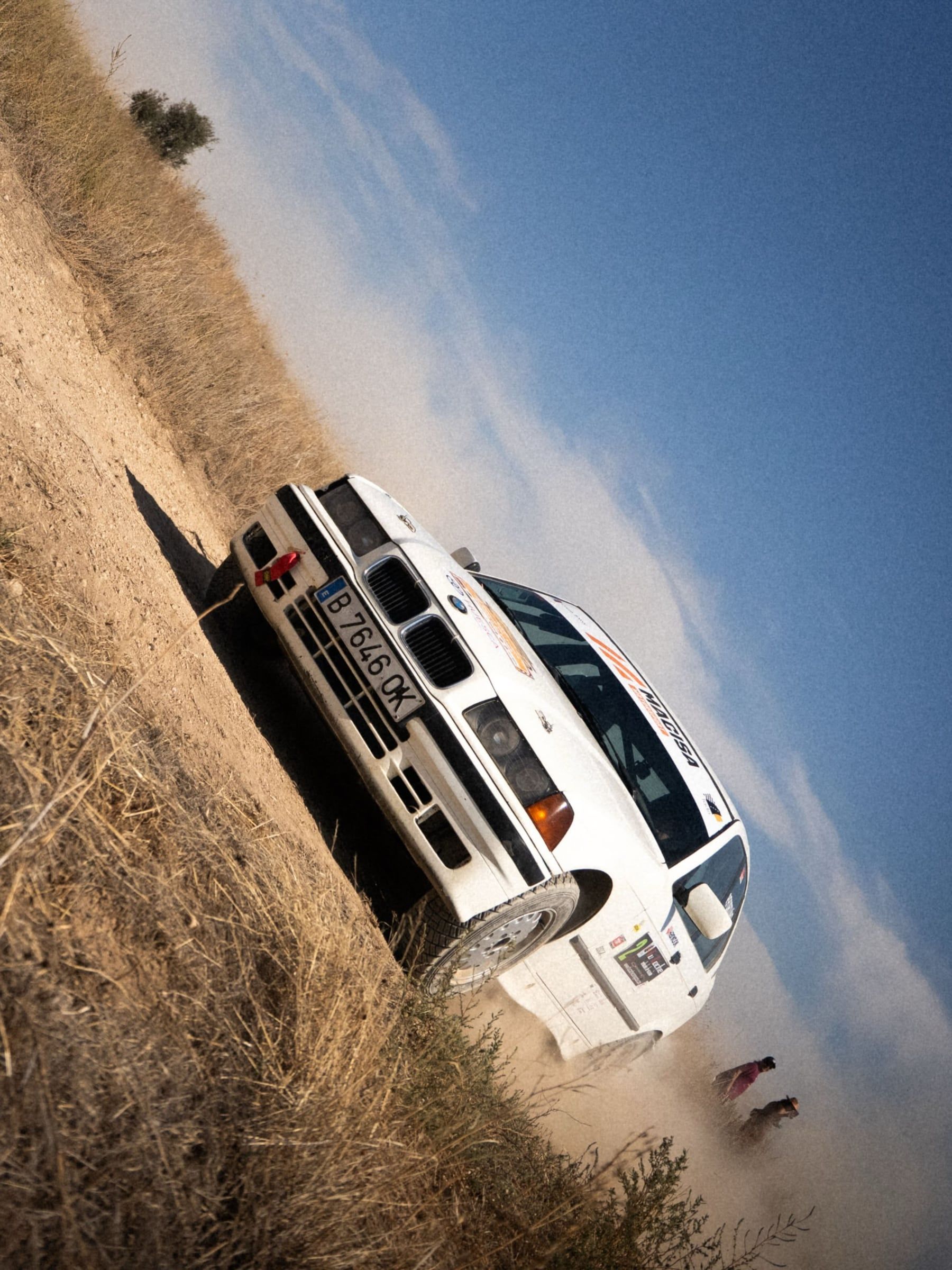 Renault blanco inclinado en el talud bajo el cielo azul